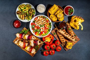 Izgara yaz bbq tabakları. Barda piknik pikniği çeşitli ızgara yiyeceklerle - şiş kebap şiş şiş, ızgara mısır, kızarmış tavuk salata, biftek, sosis, sebze