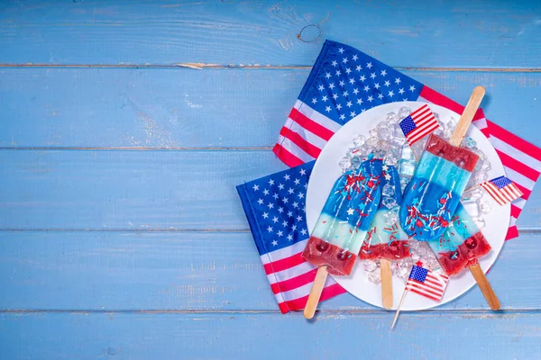 白色和蓝色的冰突然冒出来 爱国的美国棒棒糖冰淇淋 7月4日聚会或野餐用 味道鲜美的草莓味冰棒 — 图库照片