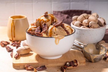 Cevizli dondurma kasesi. Geleneksel sonbahar baharatlı cevizli karamelli turta dondurması, bol karamel soslu ve fındıklı mutfak masasında fotokopi alanı.