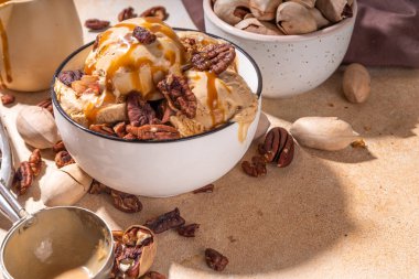 Cevizli dondurma kasesi. Geleneksel sonbahar baharatlı cevizli karamelli turta dondurması, bol karamel soslu ve fındıklı mutfak masasında fotokopi alanı.