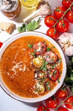 Soğuk domates kremalı çorba, baharatlı kırmızı gazpacho çorbası ızgara domates, peynir ve yeşillik, beyaz masa arkaplan fotokopi alanı.