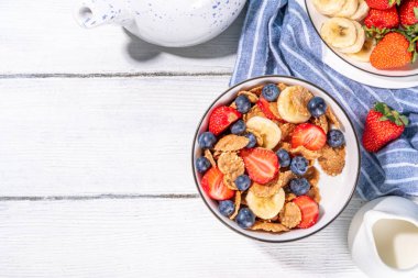 Sağlıklı vitamin diyeti yaz kahvaltısı. Mısır gevreği, yoğurtlu, sütlü, çilekli, yaban mersinli mısır gevreği, mutfak masasında fotokopi alanı.