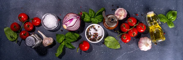 İtalyan yemekleri pişirmek için kullanışlı bir arka plan - domates, fesleğen yaprağı, yeşiller, zeytin yağı, tuz, biber, sarımsak, düz siyah beton masa üstü görünüm alanı 