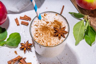Apple pie smoothie with yogurt, apple slices, oatmeal granola flakes, cinnamon, spices and walnuts. Healthy uatumn breakfast or snack, with fresh raw apples and spices copy space