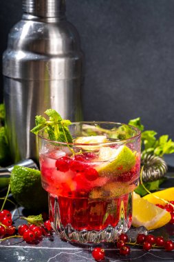 Kırmızı üzümlü limonata ya da mojito kokteyli. Frenk üzümü, limon, miint ve buz ile buzlu taze yaz kokteyli. Koyu renkli arkaplan kopyalama alanı