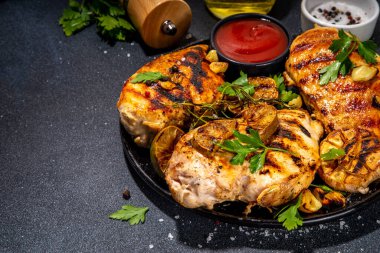 Kızarmış tavuk, hindi fileto. Baharatlı bbq kızarmış beyaz et, sarımsaklı, biberiyeli, limonlu, ketçap soslu, arka planda siyah beton masa arkaplanlı, kemiksiz fileto.