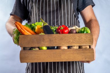 Çiftlik organik pazar alışverişi, yaz, sonbahar çiğ sebze ve meyveli ahşap kutu, çiftçi erkeklerin beyaz arka planda elleri.