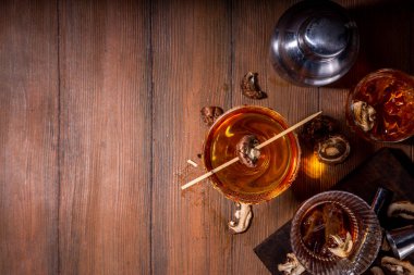 Modaya uygun sert alkol mantarı kokteyli, alkolsüz mantar çeşitli kokteyl bardaklarına doldurulmuş içecekler, siyah ahşap arka plan fotokopisinde bar aletleri.