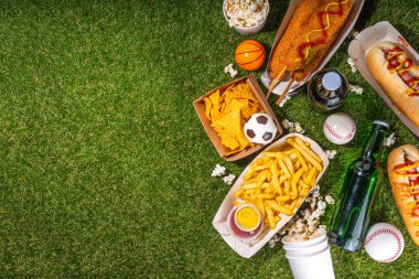 Geleneksel spor stadyumu yemekleri ve bira arka planı, çeşitli beyzbol, basketbol, futbol fanatikleri ve stadyum atıştırmalıkları, cips, sos, bira şişeli sosisliler ve fan aksesuarları. 