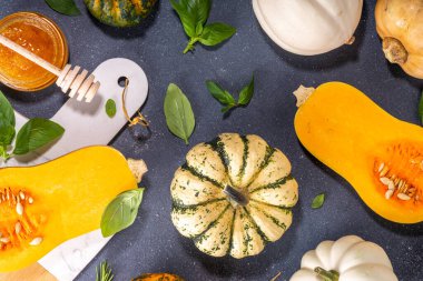 Bal kabakları değişik boyutlarda yemek pişirme arka planı, bitki ve baharatlı kabak türleri, zeytin yağı, bal, siyah mutfak masası arka planında Üst görünüm alanı 