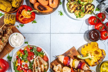 Izgara yaz bbq tabakları. Barda piknik pikniği çeşitli ızgara yiyeceklerle - şiş kebap şiş şiş, ızgara mısır, kızarmış tavuk salata, biftek, sosis, sebze