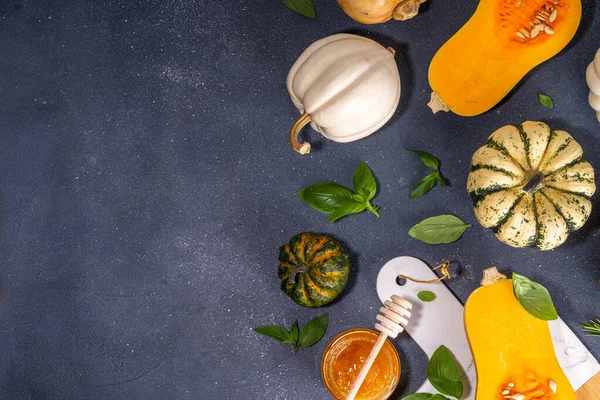 Bal kabakları değişik boyutlarda yemek pişirme arka planı, bitki ve baharatlı kabak türleri, zeytin yağı, bal, siyah mutfak masası arka planında Üst görünüm alanı 