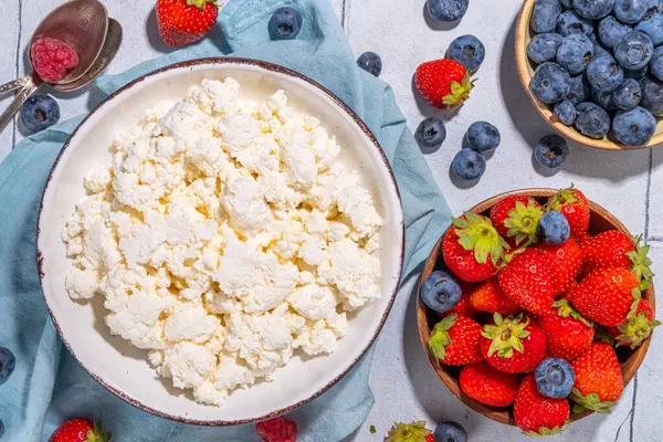 stock image Cottage cheese with berries. Bowl of cottage cheese with strawberry, blueberry, high-protein summer healthy breakfast or lunch, copy space