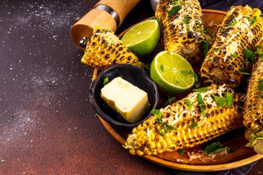 Vejetaryen bbq yemeği, ızgara tuzlanmış baharatlı mısır, tereyağı ve yeşillikler.