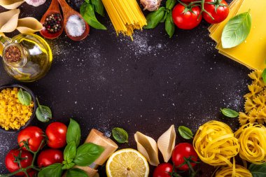 Baharatlı makarna ve yemek pişirmek için malzemeler. Hazırlık yemeği, öğle yemeği arkaplanı taze fesleğen, domates, baharat, sarımsak ve farklı çeşitte İtalyan Akdeniz makarnası.