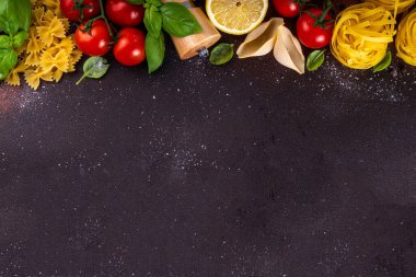 Baharatlı makarna ve yemek pişirmek için malzemeler. Hazırlık yemeği, öğle yemeği arkaplanı taze fesleğen, domates, baharat, sarımsak ve farklı çeşitte İtalyan Akdeniz makarnası.