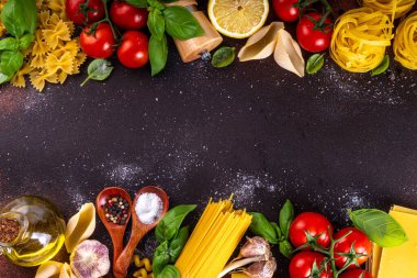 Baharatlı makarna ve yemek pişirmek için malzemeler. Hazırlık yemeği, öğle yemeği arkaplanı taze fesleğen, domates, baharat, sarımsak ve farklı çeşitte İtalyan Akdeniz makarnası.