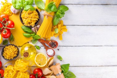 Baharatlı makarna ve yemek pişirmek için malzemeler. Hazırlık yemeği, öğle yemeği arkaplanı taze fesleğen, domates, baharat, sarımsak ve farklı çeşitte İtalyan Akdeniz makarnası.