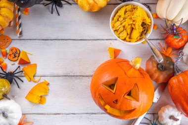 Balkabağı oyma Jack Feneri ile Cadılar Bayramı hazırlığı. Kadın, kadın ve çocuklar ellerini çerçeveye koyar, dekore eder, çizer ve korkunç Cadılar Bayramı partisini oyar.