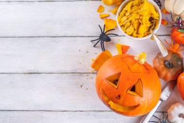 Balkabağı oyma Jack Feneri ile Cadılar Bayramı hazırlığı. Kadın, kadın ve çocuklar ellerini çerçeveye koyar, dekore eder, çizer ve korkunç Cadılar Bayramı partisini oyar.