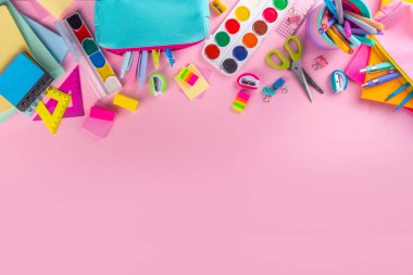 Okul ekipmanları parlak pembe düz yerde yatıyordu. Çeşitli okul ve ofis malzemeleri, aksesuarlar. Okul satışına geri dön. Üst görünüm kopyalama alanı