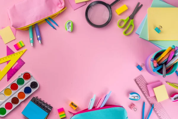 Okul ekipmanları parlak pembe düz yerde yatıyordu. Çeşitli okul ve ofis malzemeleri, aksesuarlar. Okul satışına geri dön. Üst görünüm kopyalama alanı