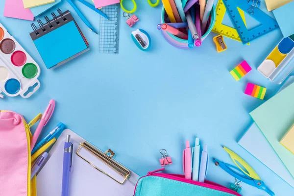 Okul ekipmanları parlak mavi düz yerde yatıyordu. Çeşitli okul ve ofis malzemeleri, aksesuarlar. Okul satışına geri dön. Üst görünüm kopyalama alanı