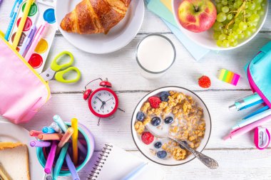 Okul çocukları için sağlıklı besleyici bir sabah kahvaltısı, taze meyve, sebze, kruvasan, müsli, süt ve sandviç. Okuldan ve işten önce kahvaltı yapmak, fotokopi çekmek.
