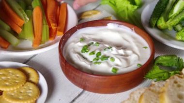 Süzme peynir yüksek proteinli sos taze sebzeler, ekmek ve krakerler ahşap masa üzerinde fotokopi alanı. Çeşitli abur cuburlarla birlikte sağlıklı peynirli diyet yemek
