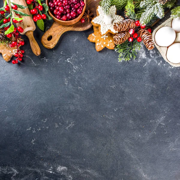 Noel yemeği, kış kurabiyesi, zencefilli çörek, meyveli kek, mevsimlik içecekler. Kızılcıklar, kurutulmuş portakallar, tarçın, baharatlar, koyu taş masadaki un, uzay manzarasını kopyala