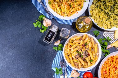 Beyaz fayanslı arka planda farklı soslu makarna seti. Spagetti, farfalle, makarna, deniz ürünleri, ıspanak, karbonara, domates soslu fusilli makarna. İtalyan yemeği, Akdeniz yemeği konsepti