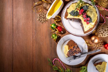 Geleneksel Noel İngiliz pudingi tatlısı. Kremalı kremalı ev yapımı meyveli puding. Noel için tatlı aromalı meyveli pasta, yeni yıl yemeği, süslü arka planda.