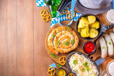  Oktoberfest Münih geleneksel festival menüleri - bavyera sosisleri, krakerler, patates, lahana turşusu, bira şişesi ve kupa, Oktoberfest davetiyesi için eski ahşap masa fotokopisi alanı