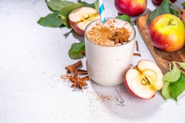 Apple pie smoothie with yogurt, apple slices, oatmeal granola flakes, cinnamon, spices and walnuts. Healthy uatumn breakfast or snack, with fresh raw apples and spices copy space