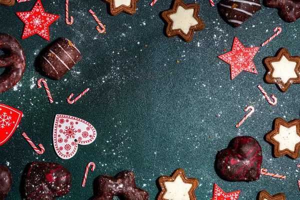 圣诞丽晶饼干 传统的圣诞巧克力姜汁与节日装饰 圣诞树枝条在深绿色桌子上方的观景复制空间 — 图库照片