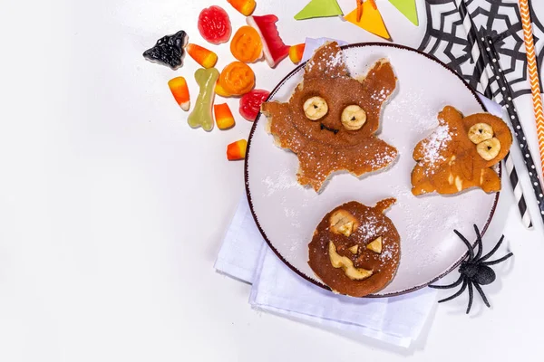 stock image Halloween creative kids breakfast. Cute homemade pancakes in the shape of Halloween holiday symbols - bat, jack pumpkin, ghost, made by cookie cuttings