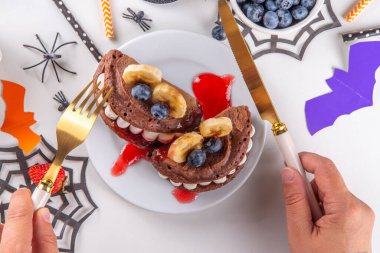 Cadılar Bayramı için komik çocuklar kahvaltısı. Geleneksel cadılar bayramı canavarları ve sembolleri şeklinde taze böğürtlen, çikolata ve kırmızı şerbetli ev yapımı tatlı krepler.