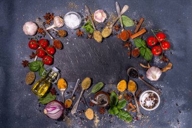 Karanlık arka planda yemek pişirmek için baharatlar. Farklı baharatlar, baharatlar ve otlar kırmızı biber, zerdeçal, tuz, fesleğen, nane, tarçın, sarımsak, zeytinyağı, hazır yemek için aromatik malzemeler.