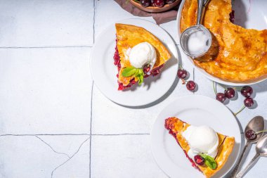 Vanilyalı dondurmalı ev yapımı vişneli pasta. Bir kepçe erimiş dondurmayla kaplı vişneli turta.