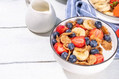 Sağlıklı vitamin diyeti yaz kahvaltısı. Mısır gevreği, yoğurtlu, sütlü, çilekli, yaban mersinli mısır gevreği, mutfak masasında fotokopi alanı.