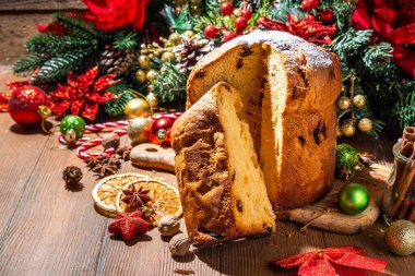 Geleneksel Noel panettone pastası. Kurumuş meyveler, baharatlar, Noel ağacı ve kırsal ahşap arka planda süslemeler. 