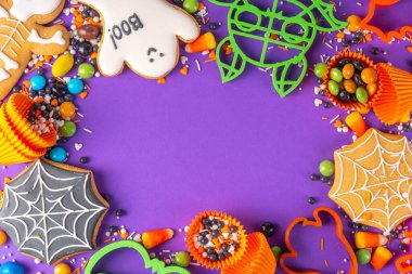 Parlak renkli Cadılar Bayramı kurabiyeleri ve tatlı bir geçmişi var. Kurabiye keskisi, şeker ve şekerli ev yapımı bisküviler. Yüksek renkli Cadılar Bayramı ziyafetleri düz görünüm kopya alanı