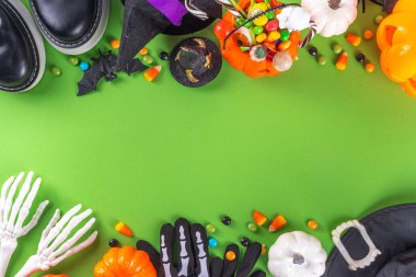 Parlak renkli Cadılar Bayramı çocukları parti aksesuarları, renkli şekerlemeler, geleneksel Cadılar Bayramı karakterleri kostümleri, şekerler, şekerler ve dekor üst görünümü ile tatil aksesuarları, şeker ya da hile