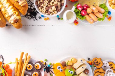 Cadılar Bayramı canavar yemekleri ve atıştırmalıklar. Çocuklar için komik yaratıcı yemekler. Cadılar Bayramı partisi, çocuklar için brunch ya da kahvaltı. Kurabiyeler, sağlıklı ve fast food atıştırmaları, kahvaltı gevrekleri, sosisli sandviçler.