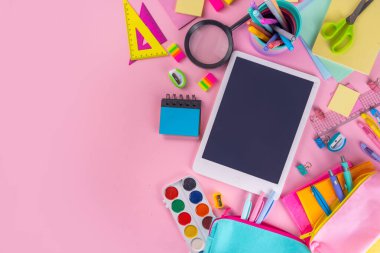 Okul ekipmanları parlak pembe düz yerde yatıyordu. Çeşitli okul ve ofis malzemeleri, aksesuarlar. Okul satışına geri dön. Üst görünüm kopyalama alanı