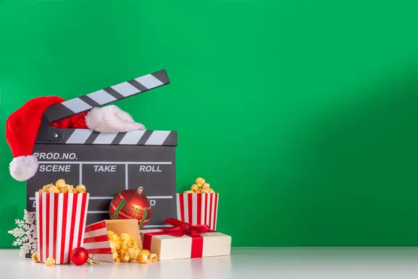 Christmas movie night part, Gather friends and family for home cinema. Invitations to New Year, Christmas movie premiere with clapperboard, Christmas tree bauble, a bucket of popcorn, Santa hat