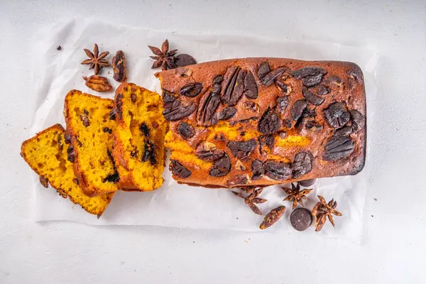 Homemade pecan and chocolate pumpkin  bread. Sliced loaded sweet dessert pumpkin bread, with nutsand chocolate drops, with ingredients top view copy space