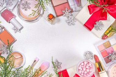 Kış ve Noel dekoratif makyaj malzemeleri, yapay kar taneleri, Noel ağacı dalları, hediye kutuları, güzellik aksesuarları. Noel ve Yeni Yıl kış kozmetik ürünleri satışı bembeyaz arka planda duruyordu