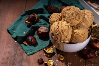 Baharatlı baharatlı dondurma, kavrulmuş kestane tadında, baharatlı, ahşap arka planda taze ve kavrulmuş kestane.
