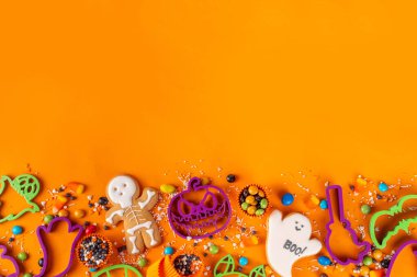 Parlak renkli Cadılar Bayramı kurabiyeleri ve tatlı bir geçmişi var. Kurabiye keskisi, şeker ve şekerli ev yapımı bisküviler. Yüksek renkli Cadılar Bayramı ziyafetleri düz görünüm kopya alanı